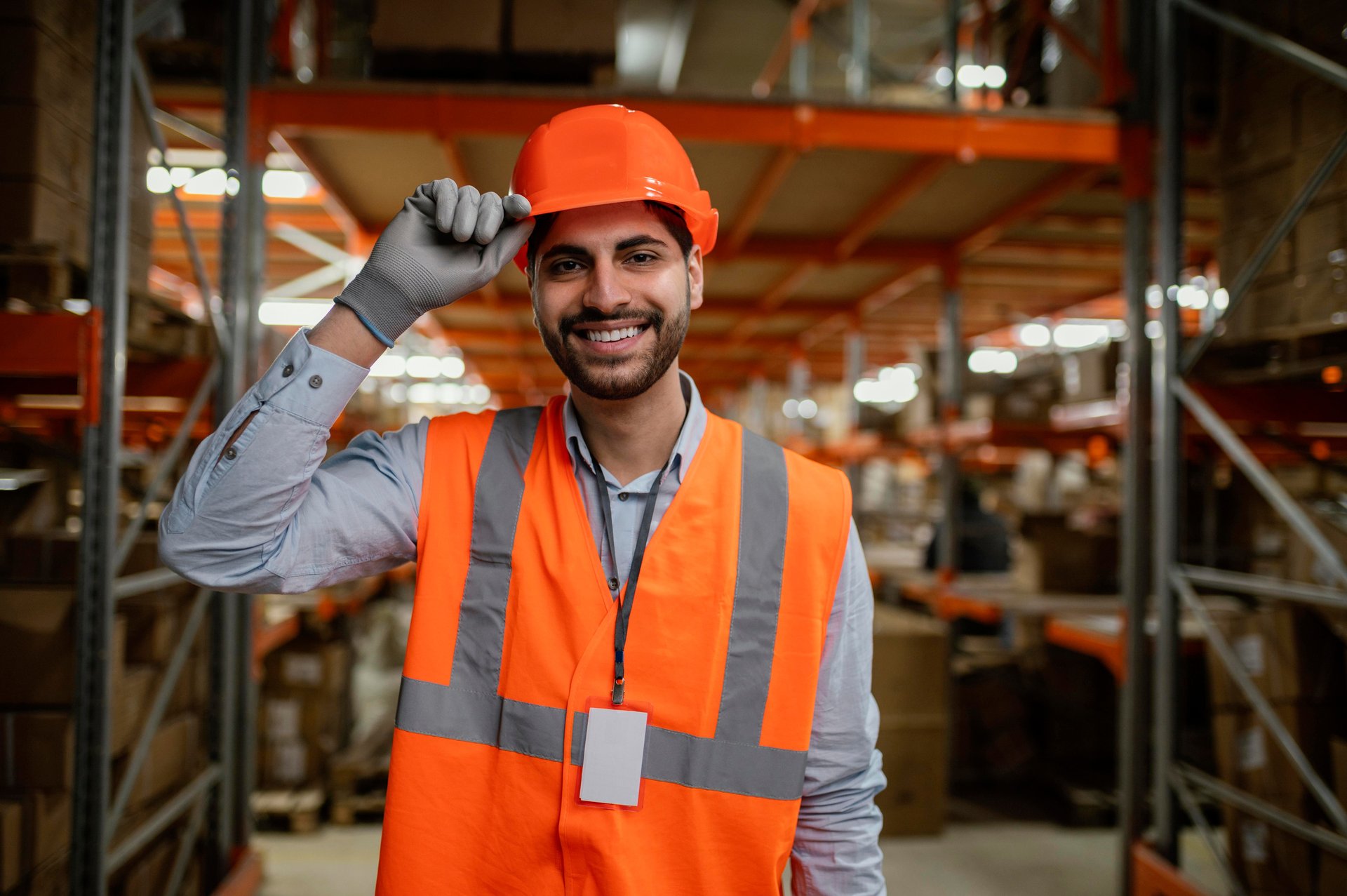 Technicien Synapse HSE souriant, casque de sécurité à la main, sur un site logistique